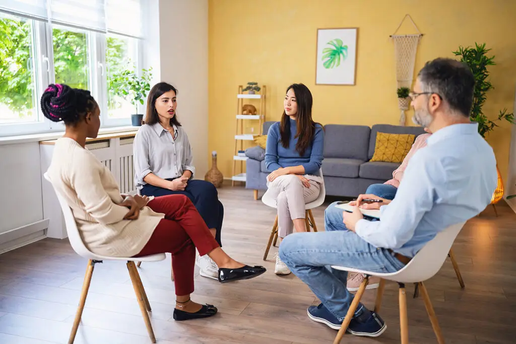 Woman sharing her thoughts during multiracial group therapy