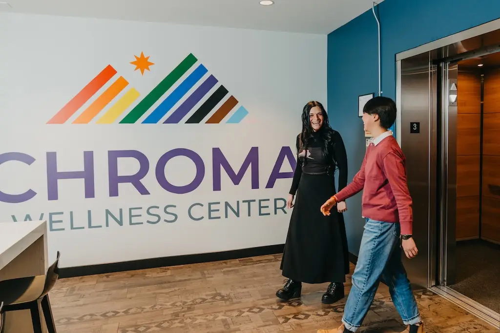 Two people walking through the lobby of Chroma Wellness Center, an LGBTQIA+ affirming mental health and substance use treatment center.