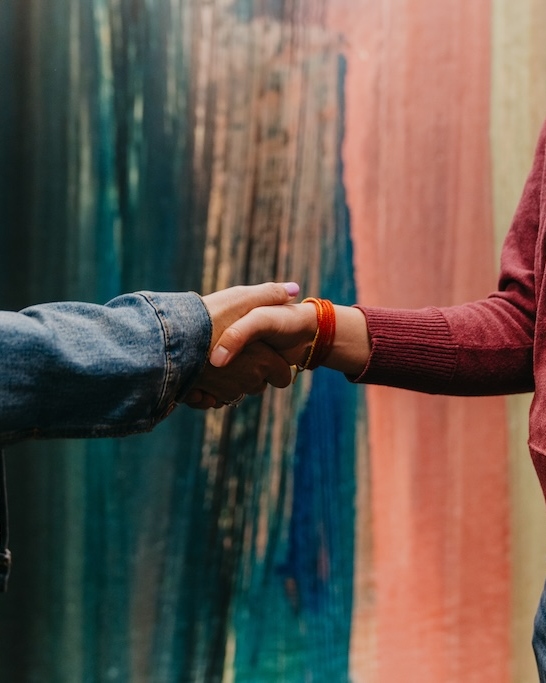 Close-up of two people shaking hands at Chroma Wellness Center, an LGBTQ+ affirming outpatient mental health treatment center in Denver.