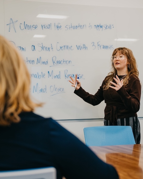 Clinician leading a structured mental health treatment session focused on trauma-informed skills and group support