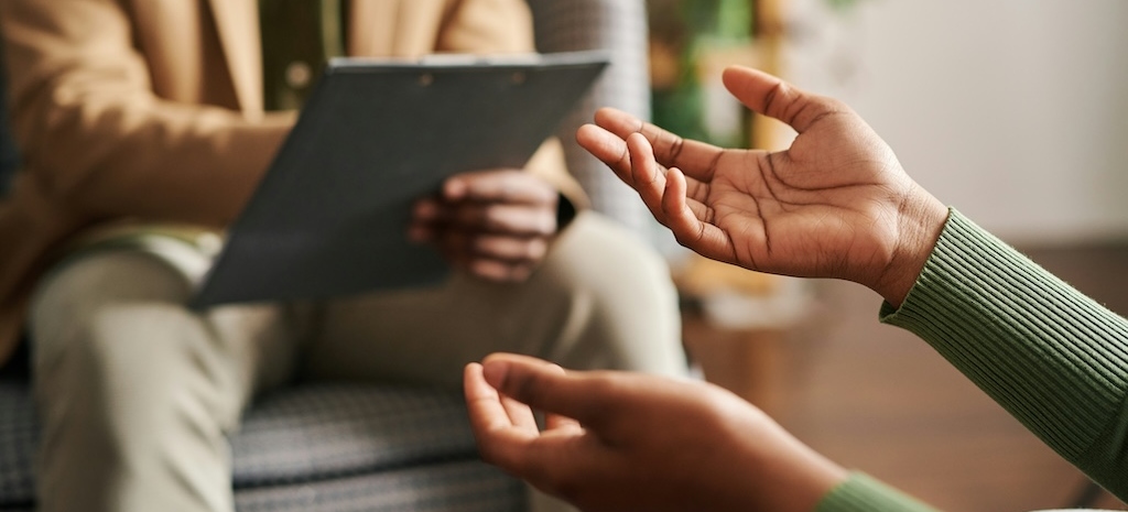 Client speaking with therapist during a one-on-one session, reflecting structured support in a trauma-informed PHP or IOP setting