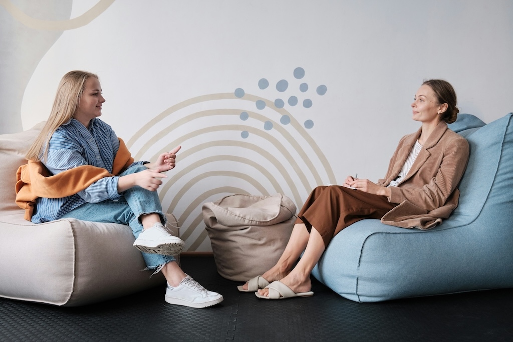 Client and therapist in a relaxed seating arrangement during a structured outpatient therapy session, reflecting supportive care in a PHP or IOP setting