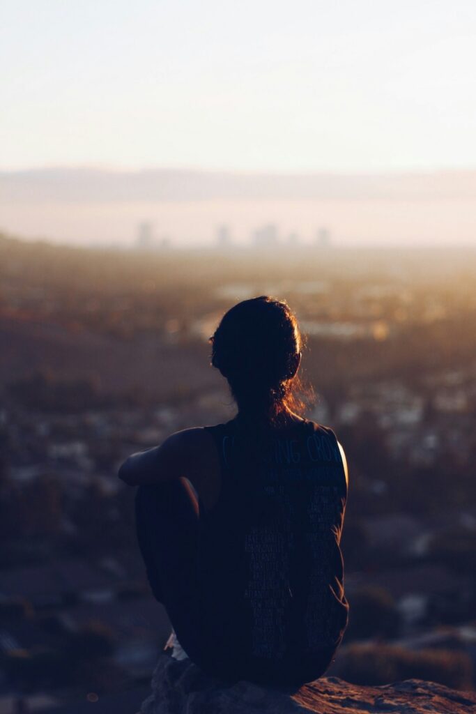 Individual sitting quietly overlooking the city, reflecting grounding and body-based awareness in somatic therapy in Denver