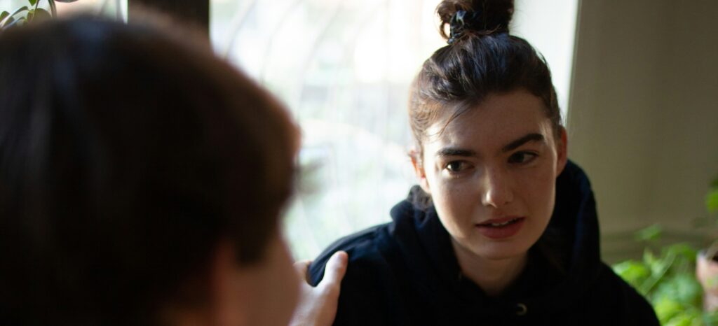 Two people engaged in a compassionate conversation, representing support, concern, and seeking help for mental health or substance use challenges.